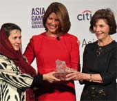 Afghan First Lady Rula Ghani (L) and former U.S. First Lady Laura Bush (R) present an Asia Game Changer award to Sherrie Weston (C), the executive vice president of Sesame Workshop. (Jamie Watts_Asia Society)