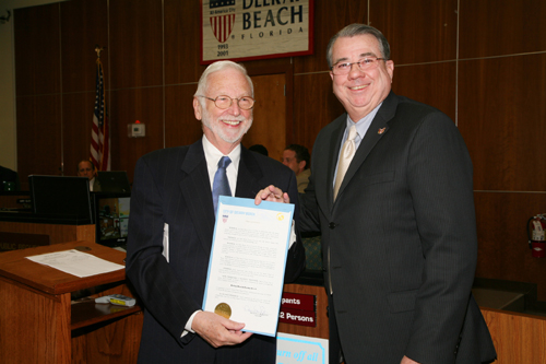 Miles Coon receives a proclamation from Mayor Woodie McDuffie declaring that January 18-23, the dates of the 6th annual Palm Beach Poetry Festival, is officially Delray Beach Poetry Week. Photo by Michiko Kurisu