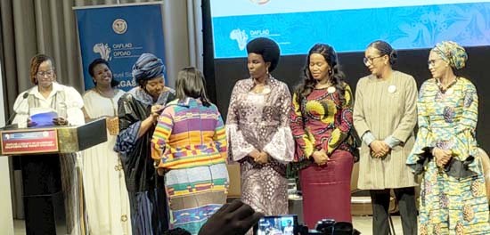 OAFLAD�s current President, the First Lady of Sierra Leone, places the #WeAreEqual campaign pin on the First Lady of Ghana