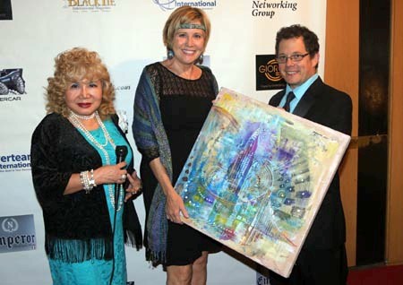 Diane McGraw accepting paintings from artist Michael Indorato