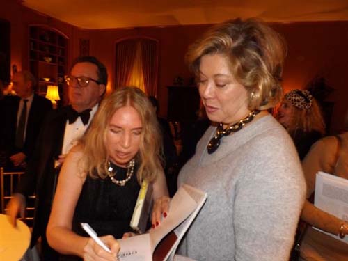 Lauren Lawrence signing her book for Patricia Kluge with Gregory Speck in the background.