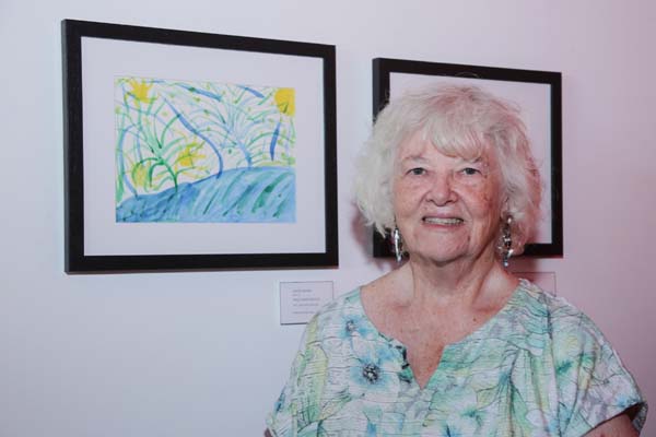  MiM artist Lenore Medina pictured with Lenores artwork entitled Trees, Water, Sun