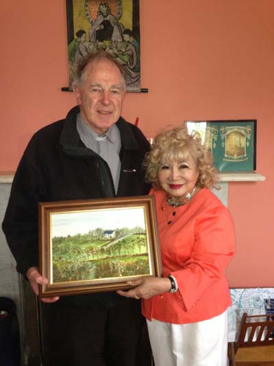  Father Nolan with the paintings of one of the local parishioners